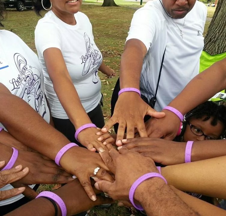 Supporters joining hands at a Love You Girl Foundation event