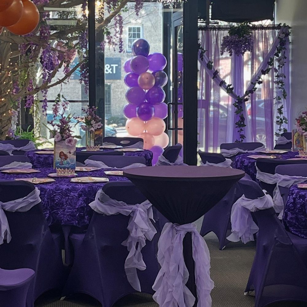 A room styled by the foundation for a party, purple linens and a balloon column